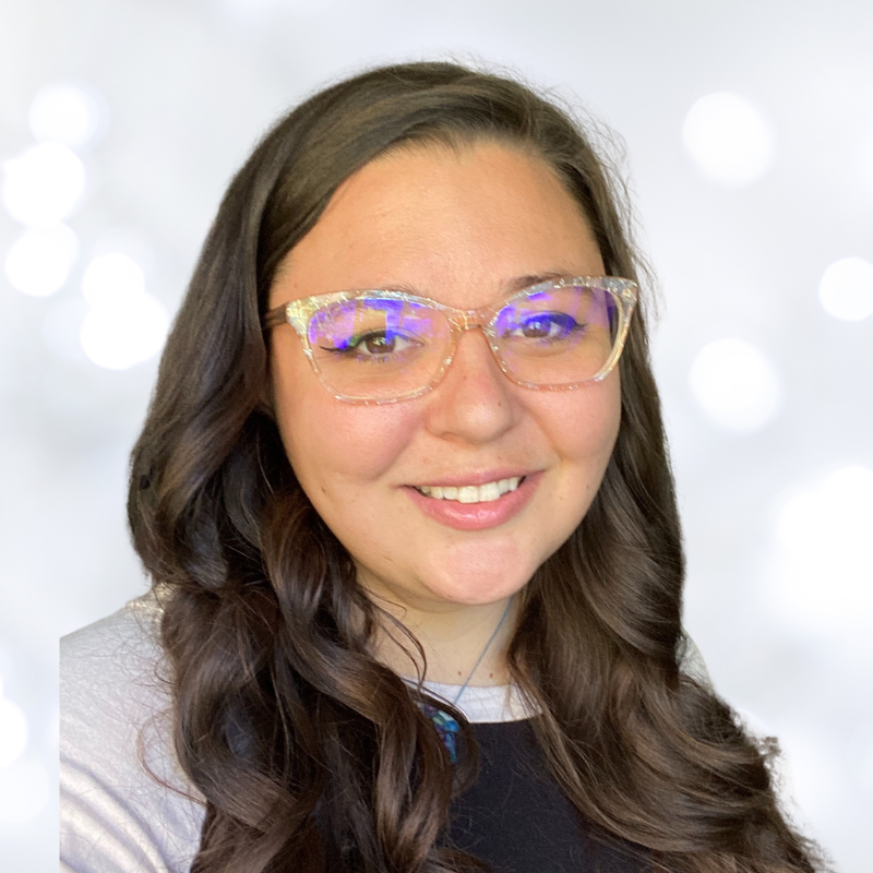 photo of a brown haired woman in glasses smiling to the camera